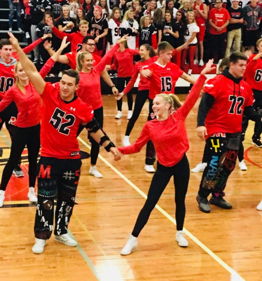 Poms team and football players perform their annual dance routine.